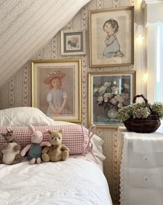 two teddy bears sitting on top of a bed in a room with pictures above it