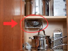 a kitchen cabinet with pots and pans in it