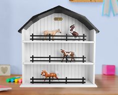 the toy horses are standing on top of the shelves