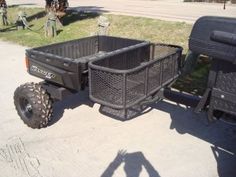 a black utility trailer with two large tires