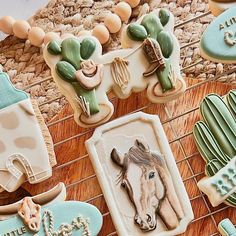 some cookies are decorated like horses and cactuses on a wire rack, along with other cookie decorating items