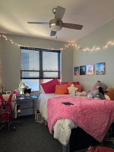 a bed room with a neatly made bed next to a window and a ceiling fan