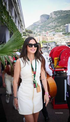 a woman wearing sunglasses and a white dress