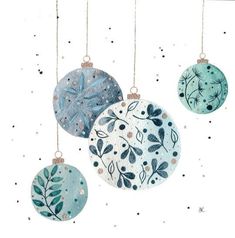 three ornaments hanging from strings with leaves on them and snowflakes in the background