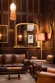 the interior of a store with brown leather furniture and accessories, including a chandelier