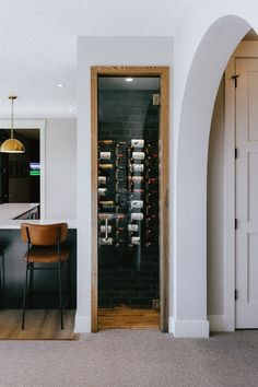 a wine rack in the corner of a room with chairs and a table next to it