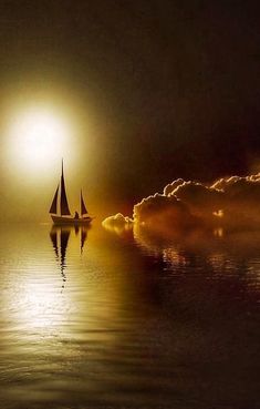 a sailboat floating in the ocean at night