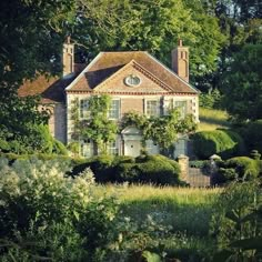 an old house surrounded by trees and bushes