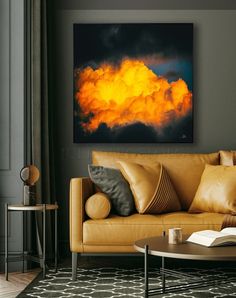 a living room with a couch, coffee table and painting on the wall above it