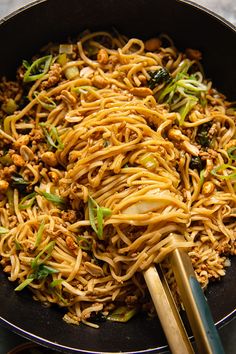 noodles and vegetables in a wok with chopsticks