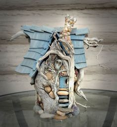 a bird house made out of driftwood and rocks