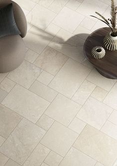 a living room with white tile flooring and furniture on the side walk, looking down at it's coffee table