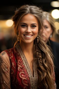 a beautiful young woman with long hair wearing a red dress and smiling at the camera