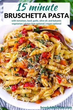 pasta with tomatoes, basil and parmesan cheese in a white bowl on top of a table