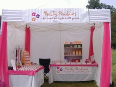 a pink and white tent is set up for an event with food on the table