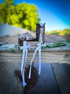 an old pair of sneakers with white ribbons tied around them sitting on top of a wooden bench