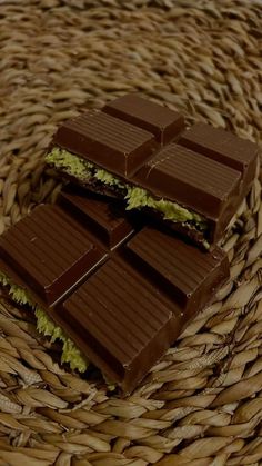 some chocolate bars sitting on top of a wicker basket filled with green lettuce