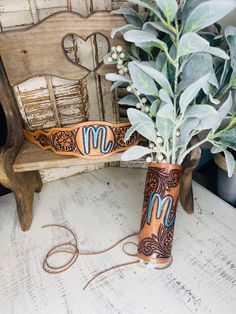 two vases with plants in them sitting on a bench next to a planter