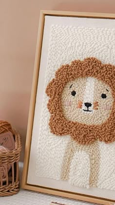 a crocheted picture frame with a lion on it next to some knitting needles