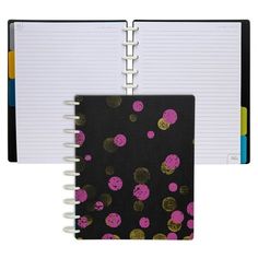 a black notebook with pink and gold polka dots on the cover, next to a spiral bound book