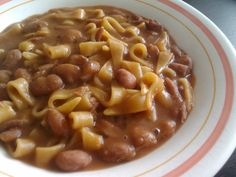 a white bowl filled with pasta and beans