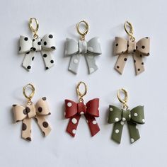 four different colored bows with polka dots are shown on a white surface, and one has a gold - plated keychain