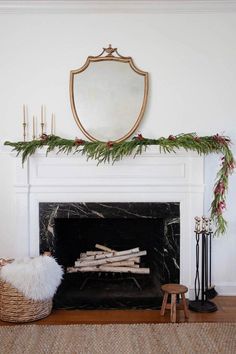 a fireplace decorated with greenery and candles