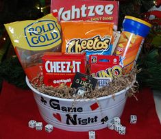 a bucket filled with candy and snacks next to a christmas tree