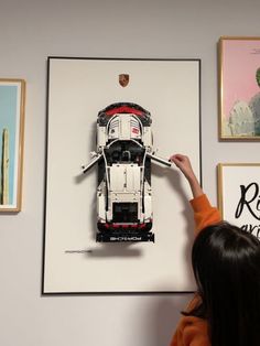 a woman pointing at a lego model of a semi - truck in front of some pictures