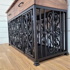 a large wooden box with iron work on the front and sides, sitting on top of a hard wood floor