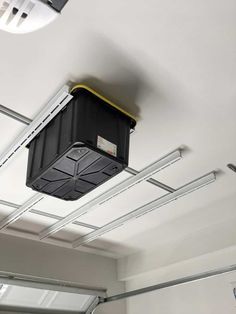 a black box suspended from the ceiling in a garage