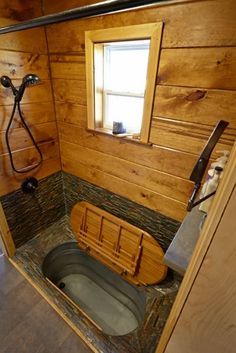 a small bathroom with a wooden tub and window