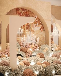 an elaborate display with chandeliers and flowers in the center is surrounded by white pillars