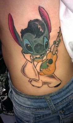 an alien with a guitar tattoo on the side of her stomach is holding a guitar