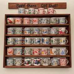 a wooden shelf filled with lots of coffee mugs