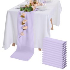 the table is set with purple napkins and place settings