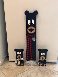 two black bears standing next to each other in front of a wall with a scarf on it