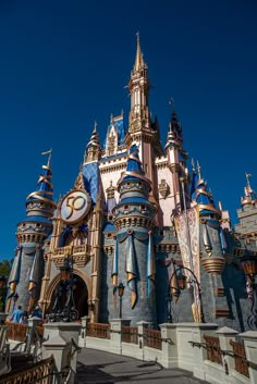 a large castle with lots of blue and gold decorations on it's sides, in front of a clear blue sky