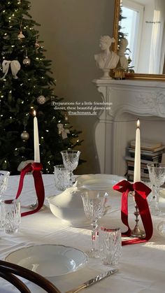 a table set for christmas with candles and plates