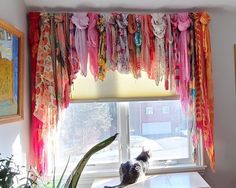 a cat sitting on a window sill looking out the window