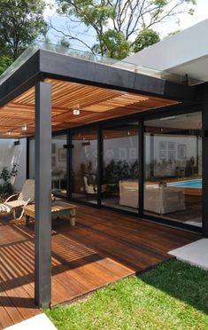 a modern house with wooden decking and glass walls