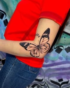 a woman with a butterfly tattoo on her arm