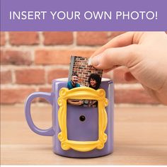 a hand holding a purple and yellow coffee mug with an inset photo in it