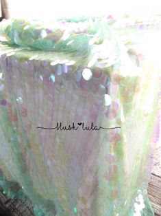 a close up of a table cloth on a wooden surface with the word hush tulla written across it