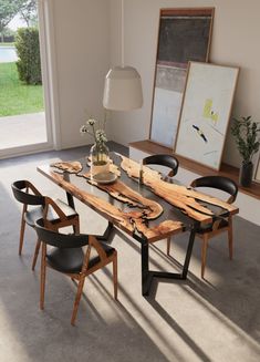 a dining room table with chairs around it and an art work hanging on the wall