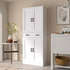 a white cabinet sitting in the corner of a room next to a table and chair