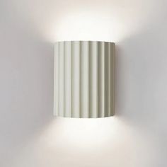 a white wall light mounted on the side of a wall