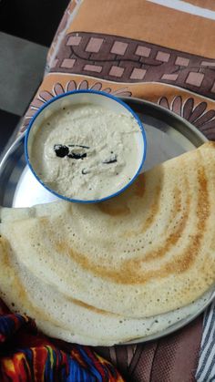 a plate with some flat bread on it and a bowl of dip in the middle