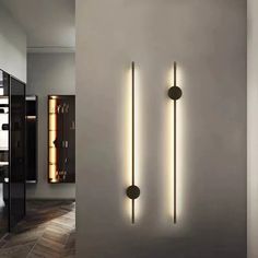 two lights are on the wall next to each other in a room with white walls