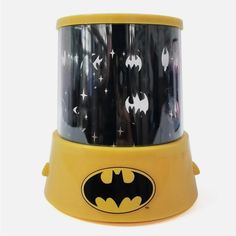 a yellow and black batman night light with stars on it's side, in front of a white background